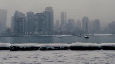 Vancouver şehir merkezinde ve False Creek 'te kar yağarken yatlar