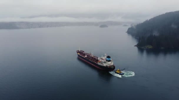 在乌云密布的天气里 与周围的云层和山峦一起飞越海湾的油轮 — 图库视频影像