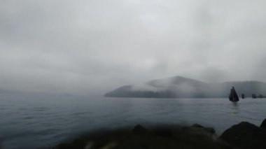 Yağmurlu bir günde, bulutlarla kaplı tepenin olduğu nehir zamanı.