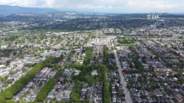 Güneşli bir günde yeşil ağaçlı Vancouver yerleşim bölgesinin havadan görünüşü