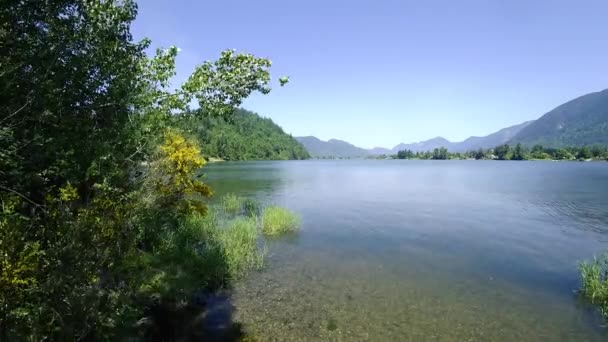 周囲の山々や漁師との晴れた日の湖のタイムラプス — ストック動画