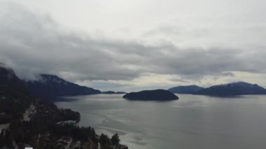 Sakin Howe Sound sularının ve bulutlu bir günde manzaralı otoyolun havadan görünüşü