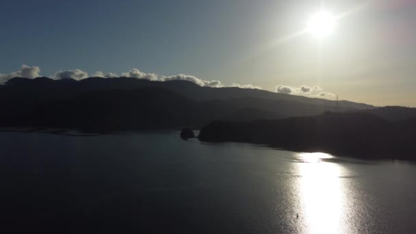 海湾水面上的阳光 背景上带着低云的高山 — 图库视频影像