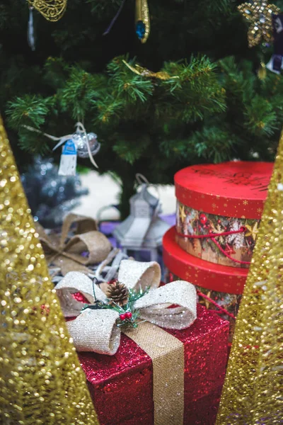 Noel ağacının altında fiyonklu hediye kırmızı kutu.