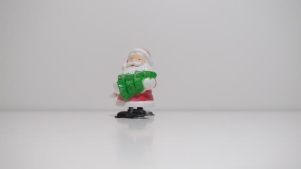 带有钟表的玩具桑塔爪与白色背景的圣诞树相遇 — 图库视频影像