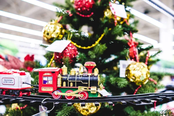Süslü bir Noel ağacının arka planında demirden bir doga üzerinde seyahat eden muhteşem bir oyuncak treni.