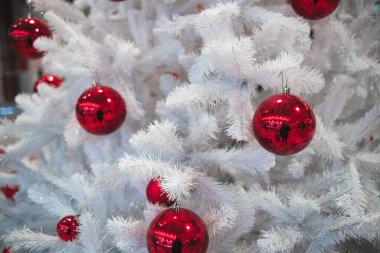 Kırmızı oyuncakları olan beyaz Noel ağacı