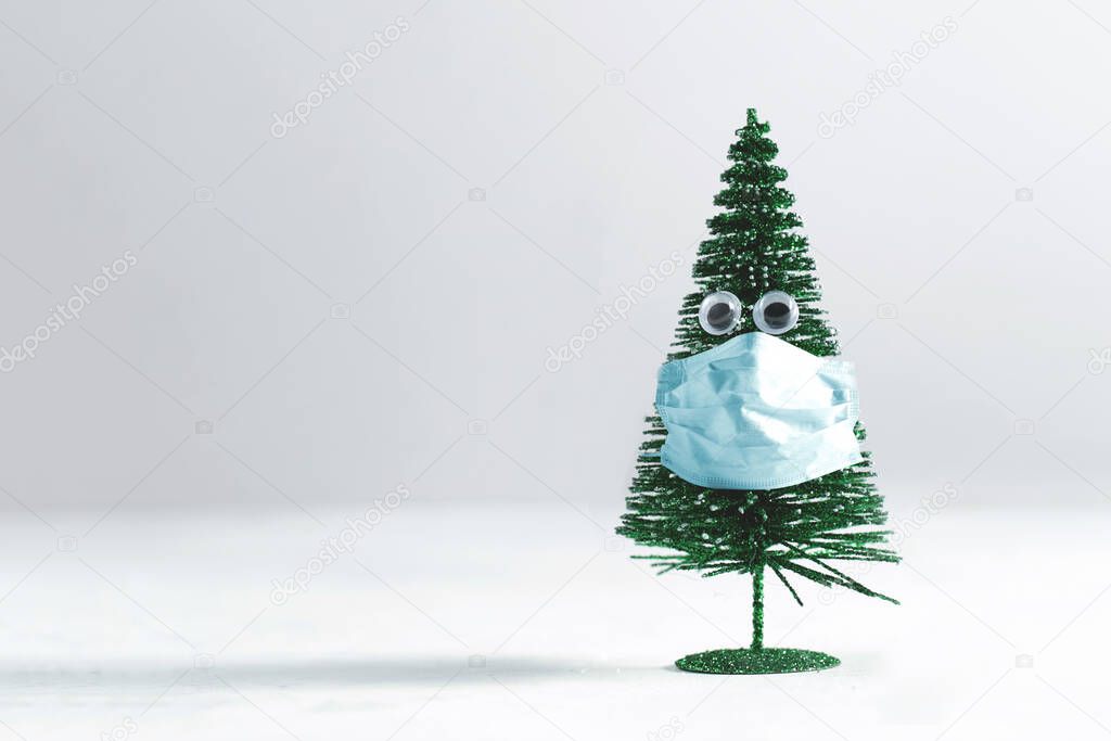 Little Christmas tree with eyes wearing a surgical mask