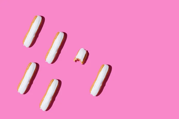 Una eclair con la cubierta blanca en el patrón de fondo rosa — Foto de Stock