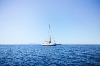Denizin ortasında beyaz, yalnız bir yat.
