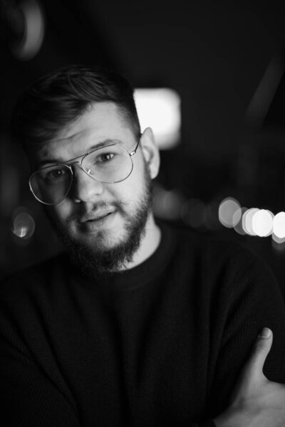 Hipster with beard young man night photography glasses close up