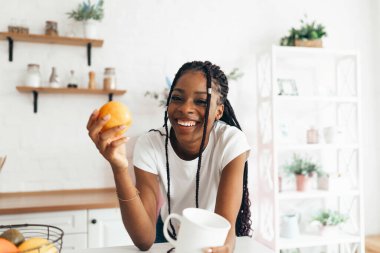 Sabahları bir fincan kahve ya da çay içen siyah bir kadının portresi.