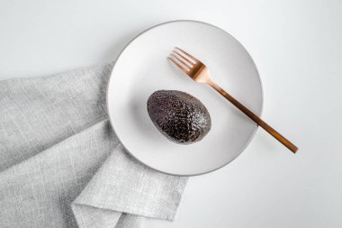 Avokado tabakta. Sağlıklı yaşam tarzı, süper yiyecekler. Altın kaşık ve çatal. Metin için yer