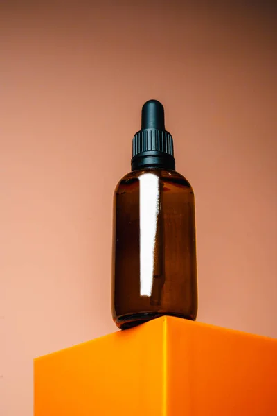 Yüzün özü kozmetik kavanozu kürsüde duruyor. Bej arka planda kozmetik ürünler. Model Vücut yağı Şişesi