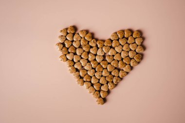 Kalp hastalığı hapları. Pembe arka planda haplardan yapılmış bir kalp. Parlak arka planda sağlıklı beslenme. Seçici odaklanma. Sağlık hizmeti, tıbbi tedavi ve hastalık önleme teması. Düz yatıyordu.