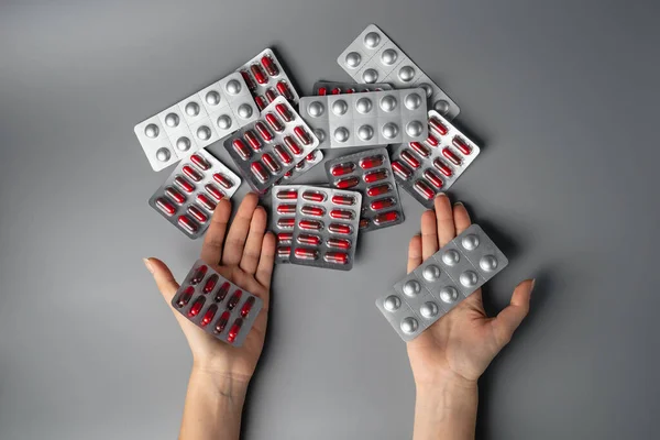 Genç bir kadın elinde haplar tutuyor. Çeşitli hastalıkların tedavileri için ilaçlar. Sağlık için antibiyotikler ve vitaminler