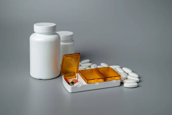 Gri arka planda haplar olan tablet kutusu. Yarın için tabletler, öğle ve akşam yemeği. Hastalık önleme