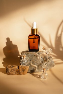 Bej arka planda yüz serumu olan bir şişe. Unisex kozmetik. Mesaj için yer. Olgun cilt için esans ayakta duruyor. Spa doğal organik ürünler. Erkekler ve kadınlar için yaş karşıtı kozmetik ürünler.