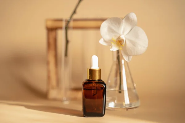 Bej bir arka planda deri sağlığı için esans. Kozmetik ürünlerinin oluşturulduğu laboratuvar. Orkide özütü. Egzotik çiçekler. Erkekler ve kadınlar için Unisex kozmetikleri.