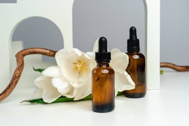 Koyu cam bir kavanozda masaj yağı. Deri sağlığı için esans kemerlerin arka planına karşı. Moda tarzı. Geometrik şekiller. Monokrom tarzında fotoğraf. Ürününün modeli. Kavramsal fotoğraf. 