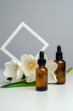 Koyu cam bir kavanozda masaj yağı. Deri sağlığı için esans kemerlerin arka planına karşı. Moda tarzı. Geometrik şekiller. Monokrom tarzında fotoğraf. Ürününün modeli. Kavramsal fotoğraf. 