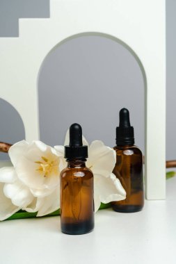 Koyu cam bir kavanozda masaj yağı. Deri sağlığı için esans kemerlerin arka planına karşı. Moda tarzı. Geometrik şekiller. Monokrom tarzında fotoğraf. Ürününün modeli. Kavramsal fotoğraf. 