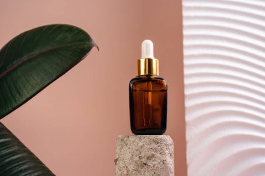 Esans şişesi pedistalde. Beyaz arka planda losyon. Cilt sağlığı için kozmetik. Aromo Petrol. C vitamini serumları, Unisex kozmetik ürünleri. Model. 