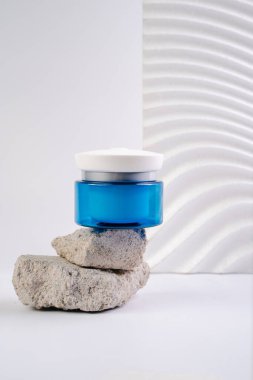 Beyaz arka planda mavi kavanozda yüz kremi. Genç cildine krem sür. Vücut bakım losyonu. Yaşlanma önleyici kırışıklık önleyici krem. Konsept fotoğraf.