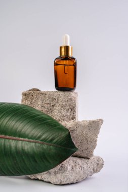 Esans şişesi pedistalde. Beyaz arka planda losyon. Cilt sağlığı için kozmetik. Aromo Petrol. C vitamini serumları, Unisex kozmetik ürünleri. Model. 