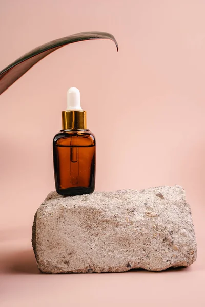 Esans şişesi pedistalde. Beyaz arka planda losyon. Cilt sağlığı için kozmetik. Aromo Petrol. C vitamini serumları, Unisex kozmetik ürünleri. Model. 