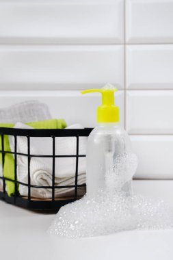 Beyaz fayans zemininde şampuan. Duş jeli ve banyoda orkideler. Cilt sağlığı için kozmetik. Logon için bir model. Kopya alanı olan banyo modeli. Şampuan şişesi ya da duş jeli.