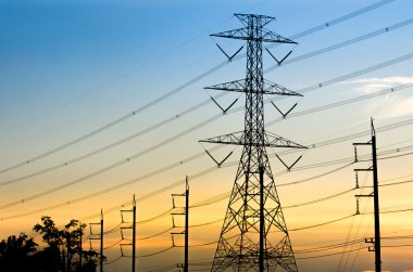 Yüksek voltajlı elektrik iletim kule günbatımı backgrou ile