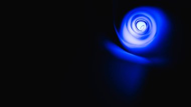 Mavi ışığı ve siyah arkaplanı olan bir kağıdın yakın plan resmi..