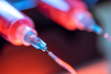 Kırmızı sıvı ortamı şırıngalardan ve esnek tüplerden bilimsel bir laboratuvar deneyinde kullanmak üzere küçük bir çip oluşturun..