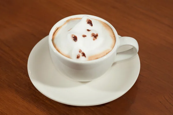 Una taza de café capuchino con patrón animal en una taza blanca en — Foto de Stock