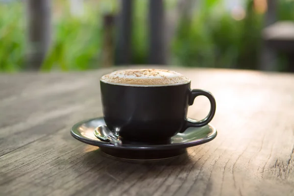 Xícara de café cappuccino quente na mesa de madeira no jardim — Fotografia de Stock