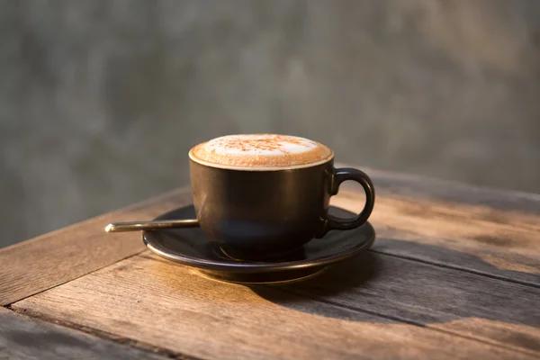 Taza de café capuchino caliente en mesa de madera — Foto de Stock