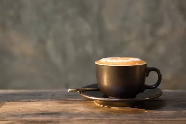 Taza de café capuchino caliente en la luz del sol agente de mesa de madera en la mañana —  Fotos de Stock