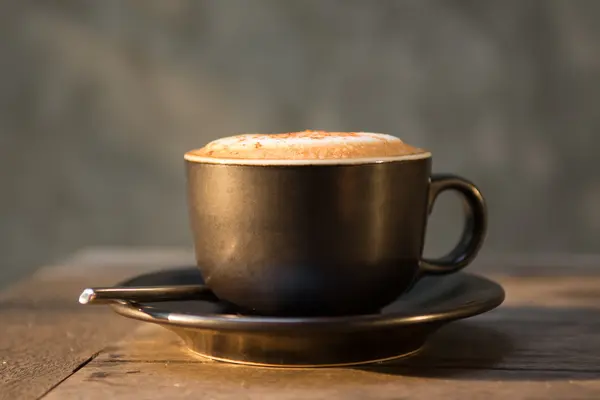 Xícara de café cappuccino quente na luz solar agente de mesa de madeira na manhã — Fotografia de Stock