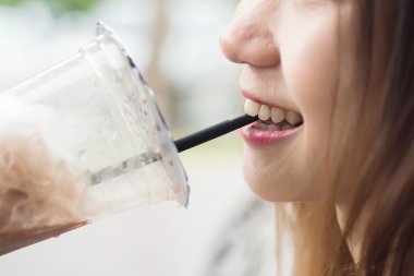 Asyalı kız ve çikolata soğuk içecek bir fincan zekâ içinde dudak yukarı kapatın