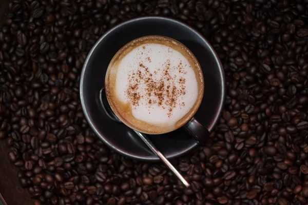 Café cappuccino sur grains de café torréfié comme fond — Photo