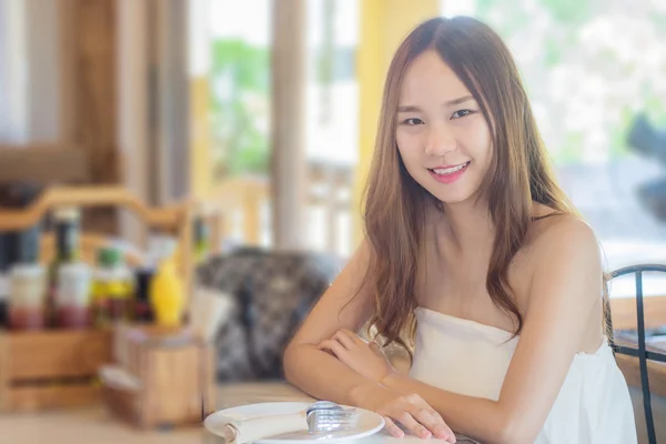 Азія жінка, що сидить у ресторані з посмішкою як ресторан фонової м — стокове фото
