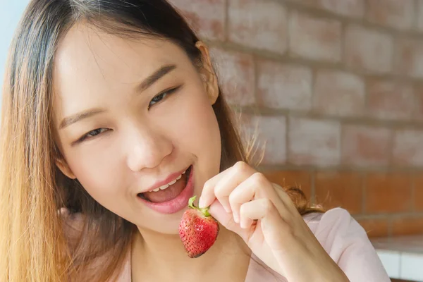 Hermosa mujer asiática disfrutar comiendo fruta de fresa . — Foto de Stock