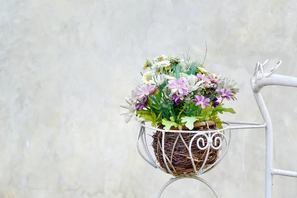 Old bicycle with flowers in metal basket on concrete wall backgr — Stock Photo, Image