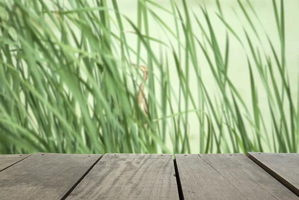 Desenfoque e imagen borrosa de la terraza de madera y bosque verde cerca de la terraza para el uso de fondo — Foto de Stock