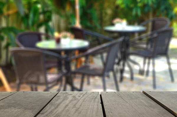 Imagen desenfocada y borrosa de terraza de madera y jardín de cafetería para uso de fondo — Foto de Stock
