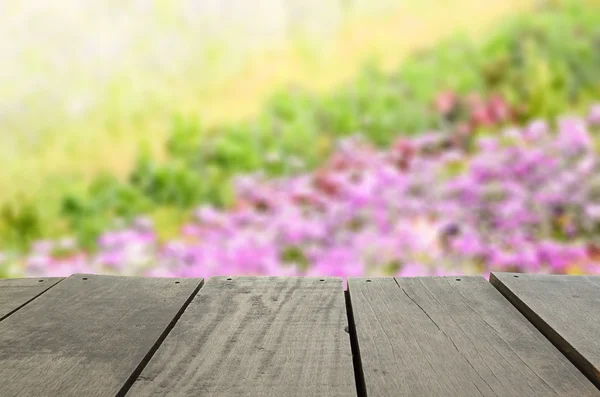 Imagen desenfocada y borrosa de madera de terraza y hermoso campo de fower violeta para uso de fondo — Foto de Stock