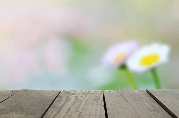 Imagen desenfocada y borrosa de madera de terraza y jardín de margarita verde en la mañana para uso de fondo —  Fotos de Stock