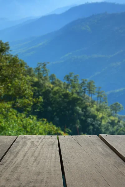 Imagem desfocada e desfocada de madeira de terraço e bela montanha para uso de fundo — Fotografia de Stock