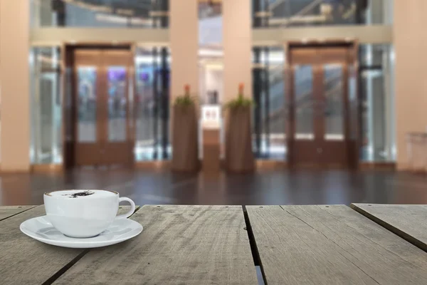 Defocus with terrace wood and cappuccino coffee with elevators in shopping mall for background usage — Stock Photo, Image